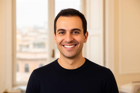 Nicola D'Auria, career coach professionista di Ore Clarity, in un ufficio luminoso a Roma con vista sulla citt&agrave;, sorridente e in abito professionale